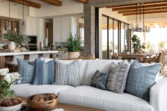 Open-plan living space with curated cushions, modern lighting, and layered textures for depth